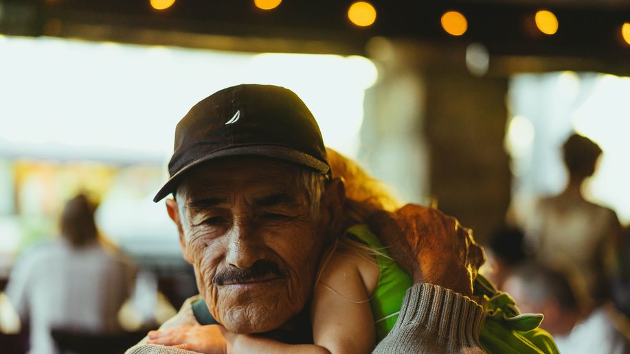 Older man carrying sleeping girl in his arms